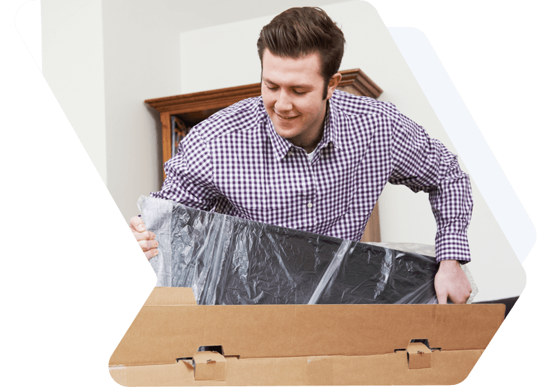 A smiling man unpacks a moving box