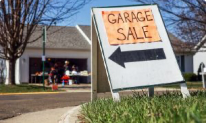 A garage sale sign on a suburban lawn