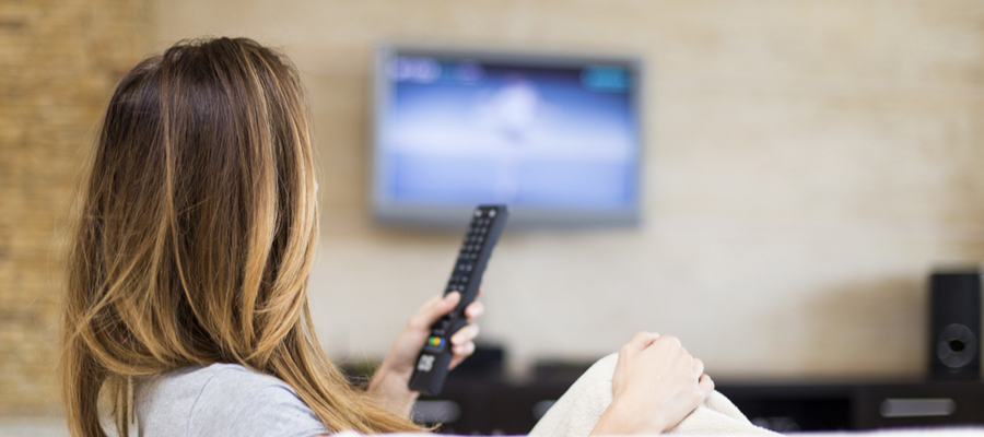 Woman holding a remote watching TV